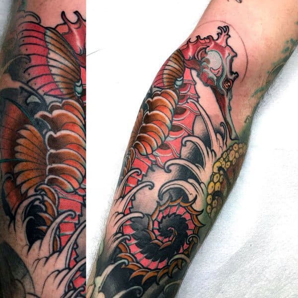 Japanese-style seahorse tattoo on forearm, featuring bold red and black hues, intricate wave patterns, and flowing details for a dynamic look.