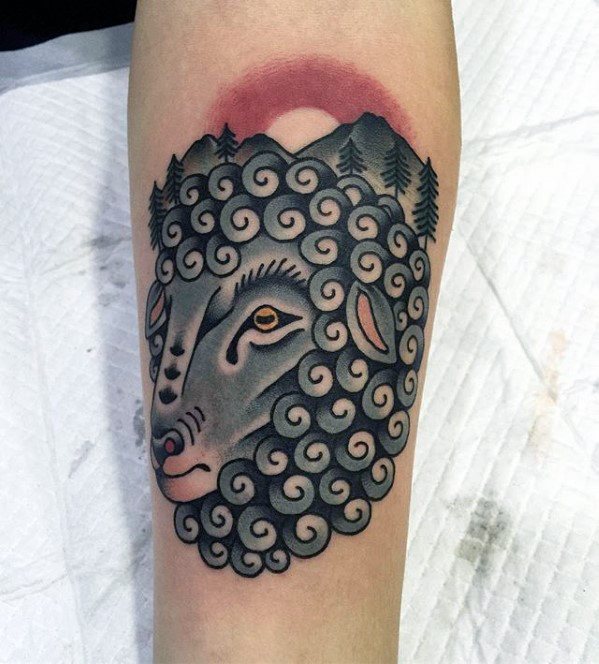 Tattoo of a curly-haired goat with a mountain and sunrise background