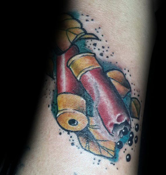 Bold shotgun shell tattoo with red and gold casings, surrounded by leaves and ink splatter effects for a dynamic and rugged design.