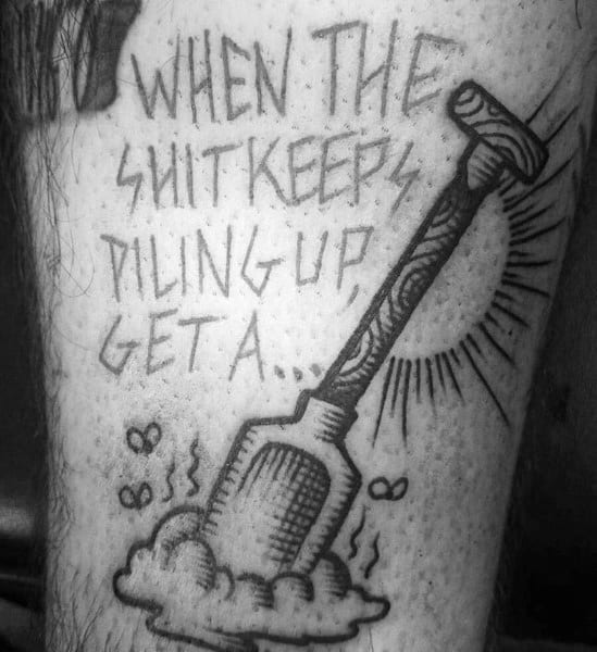 Black ink tattoo of a shovel stuck in a pile with flies around, featuring the phrase "When the shit keeps piling up, get a..." in bold lettering.