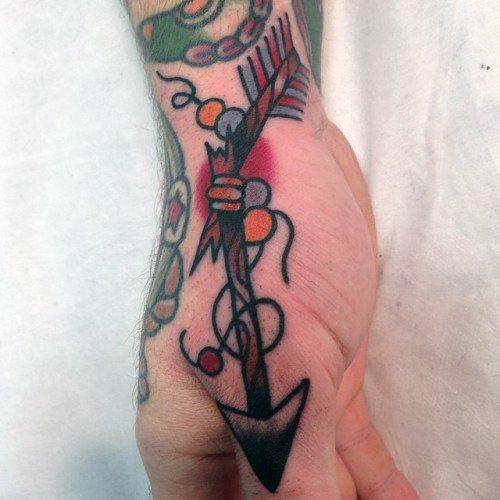 Traditional broken arrow tattoo on the hand with bold black outlines, vibrant red and orange accents, and decorative looping ribbons.