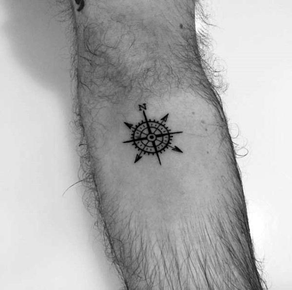Small minimalist compass tattoo with bold black lines, offering a sleek and timeless design that symbolizes guidance and direction.