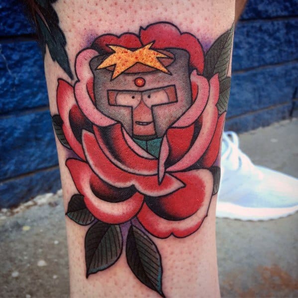 South Park tattoo of Butters as Professor Chaos, emerging from a bold, traditional-style red rose with vibrant colors and shading.