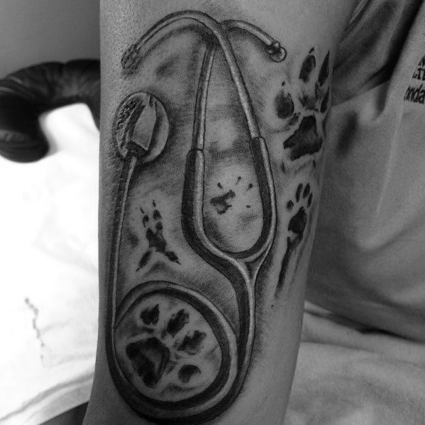 Stethoscope tattoo with paw prints, symbolizing a passion for veterinary medicine and a deep love for animals and their care.