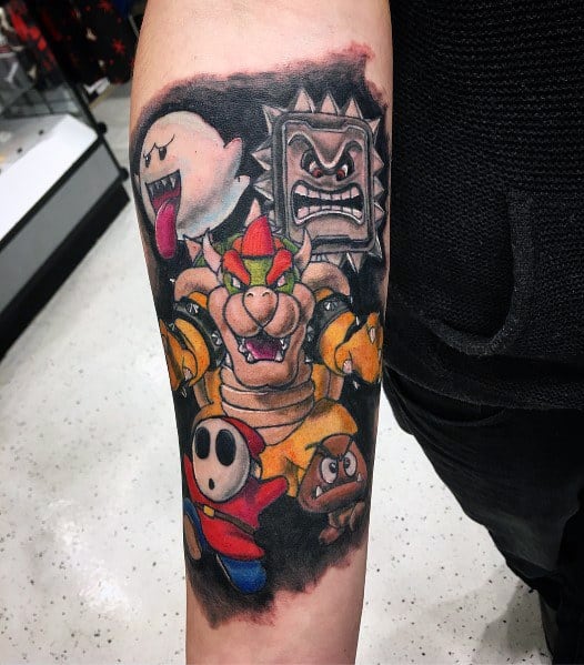 Bold Bowser tattoo on a man's forearm featuring Boo, Thwomp, Shy Guy, and Goomba with dynamic shading and a fierce Mario-themed design.