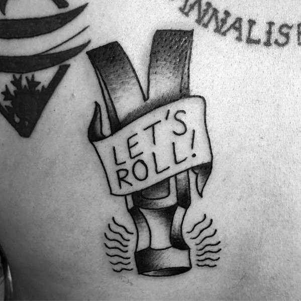 Black and gray tattoo of a hammer with a "LET'S ROLL!" banner, symbolizing strength, determination, and a hardworking spirit.