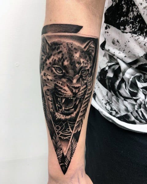 Realistic roaring big cat tattoo on the forearm, framed within a geometric triangle, creating a bold and powerful design.