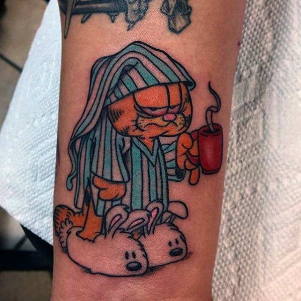 Garfield tattoo in pajamas and bunny slippers, holding coffee with a grumpy morning look—perfect for caffeine lovers and night owls.