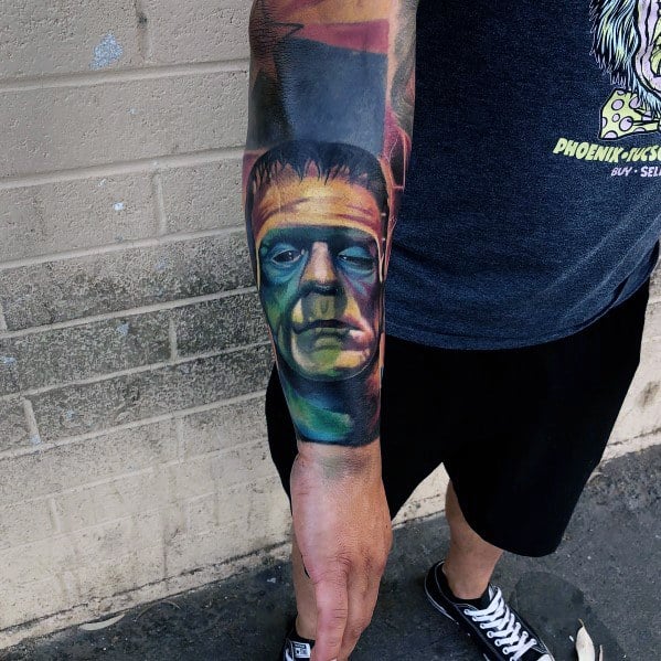 Frankenstein’s monster tattoo in a realistic style, covering the forearm with bold colors and shading for a dramatic effect.