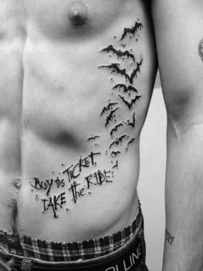 Black and white Hunter S. Thompson-inspired tattoo featuring bats flying upward and the phrase "Buy the Ticket, Take the Ride" in bold lettering.