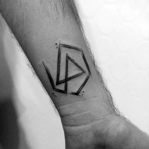 Minimalist black Linkin Park logo tattoo on the wrist, featuring a rough, sketch-style design with subtle shading.