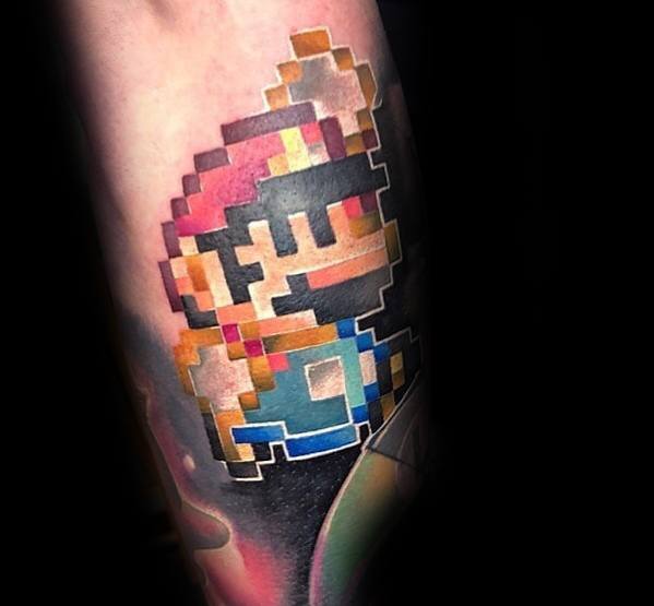 Pixelated *Super Mario* tattoo with a retro 8-bit design, featuring bold colors and shading for a nostalgic tribute to classic gaming.