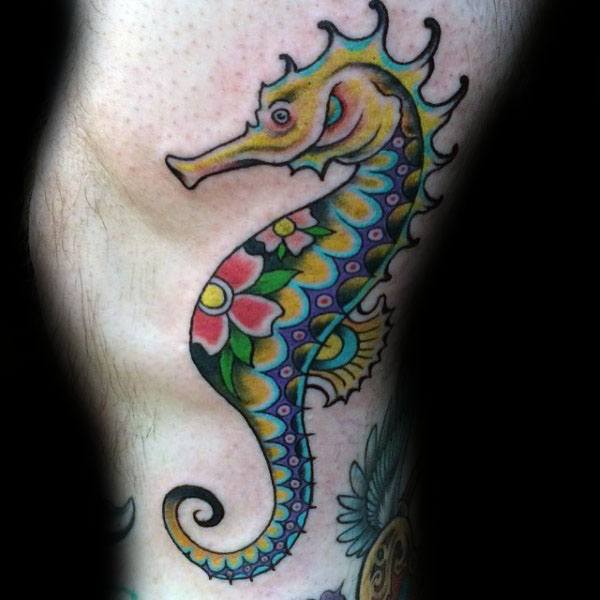 Colorful neo-traditional seahorse tattoo on leg, featuring bold outlines, vibrant floral patterns, and intricate shading for a striking design.