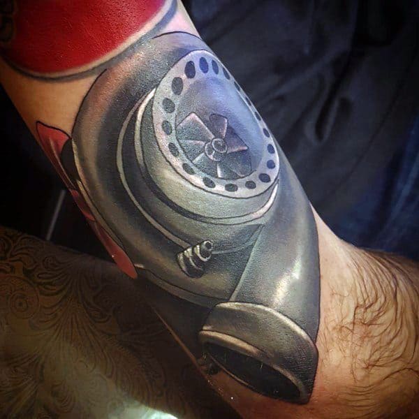 Realistic turbocharger tattoo on the forearm with bold shading and metallic effects, symbolizing speed, power, and a passion for automotive performance.
