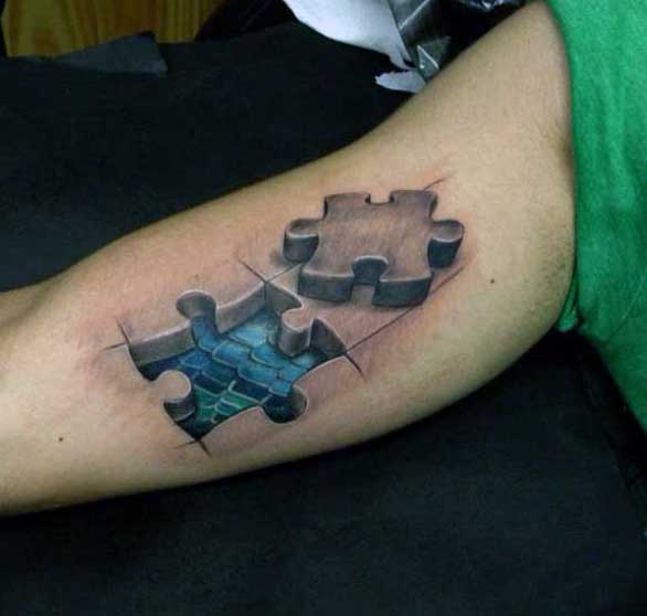 Male Tattoo Puzzle On Bicep With Blue Scales Inside