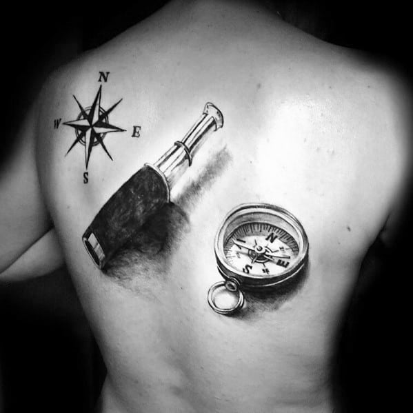 Black and gray tattoo featuring a compass, a telescope, and a nautical compass rose on the back