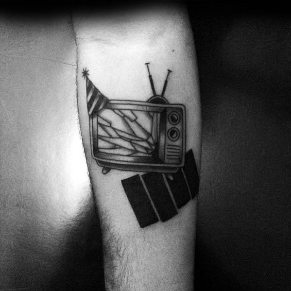 Tattoo of a vintage TV with cracked screen and party hat, tilted over Black Flag bars for a chaotic punk-meets-pop culture vibe.