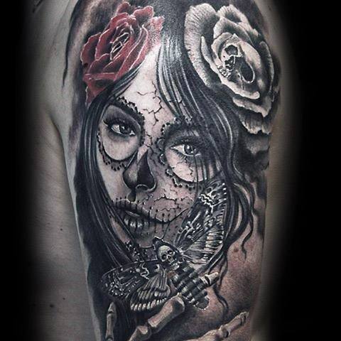 La Catrina tattoo of a woman with sugar skull makeup, red and white roses in her hair, and a detailed skull moth near her lips.