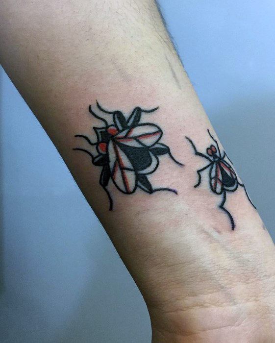 Two stylized fly tattoos on the forearm with bold black and red ink, featuring exaggerated shapes for a playful, modern look.