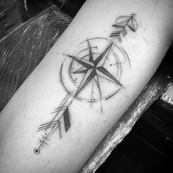 Geometric arrow and compass tattoo with fine lines, dotted details, and directional elements creating a bold forearm design.