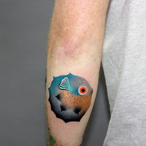 Colorful gradient tattoo of a pufferfish with a vibrant orange and blue body, black spines, and a bold red eye on the forearm.