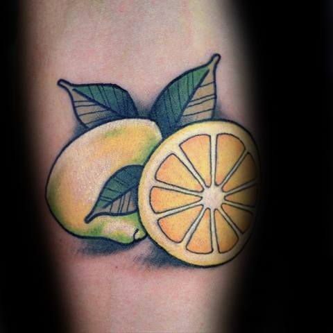 Colorful tattoo of a whole lemon and a lemon slice with bold outlines, green leaves, and soft shading for a vibrant, classic look.