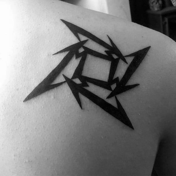 Solid black Metallica ninja star logo tattoo on the upper shoulder, featuring sharp edges and clean, symmetrical lines.