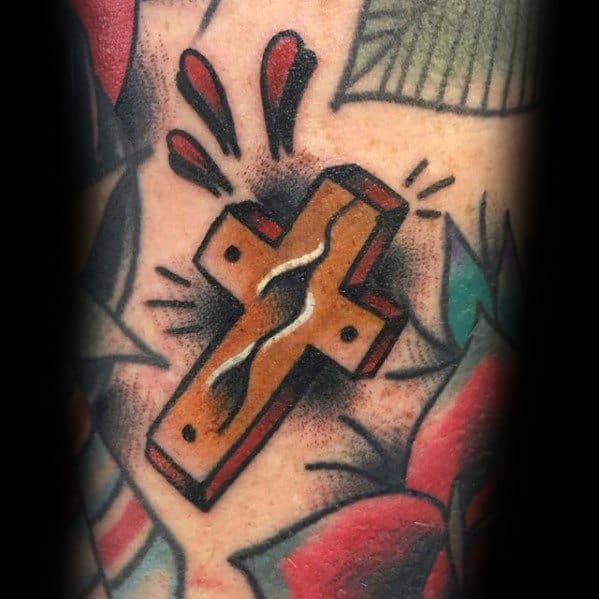 Traditional wooden cross tattoo with nails and a central crack, surrounded by bold black shading and red accent marks.