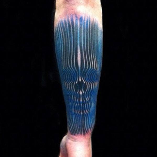 Trippy optical illusion tattoo on a man's leg with vertical blue lines forming a hidden skull in the design.