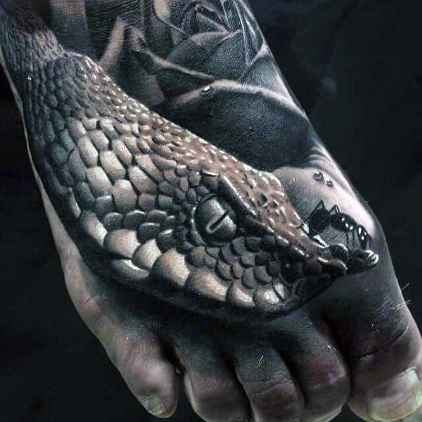 Tattoo of a realistic snake wrapping around a foot with detailed scales and shadows