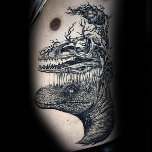 Male With Bony Branches Sprouting Out Of Dinosaur Tattoo On Side Ribs