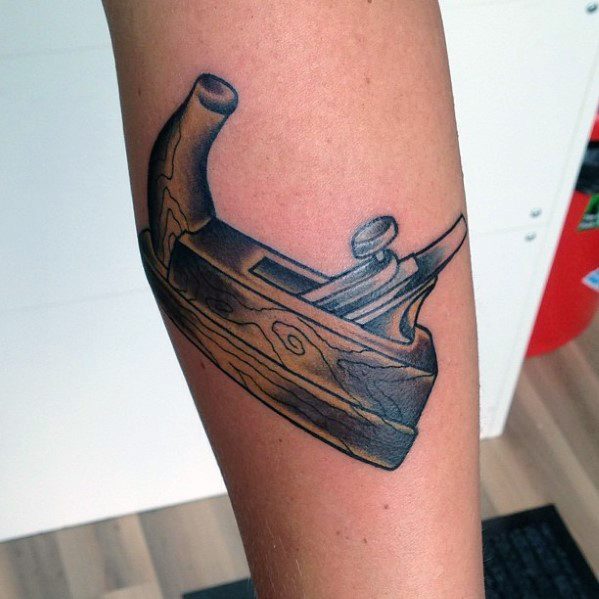 Tattoo of a traditional wood plane with wood grain details, symbolizing craftsmanship, woodworking skills, and dedication to the trade.