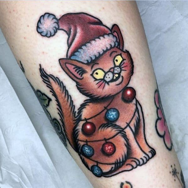 Christmas tattoo of a playful cat wearing a Santa hat, wrapped in colorful ornaments, with a mischievous expression for a festive and fun holiday design.