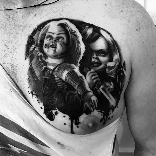 Black and grey Chucky and Tiffany tattoo with intense shading, featuring their sinister expressions, weapons, and a dripping ink effect for a bold horror design.