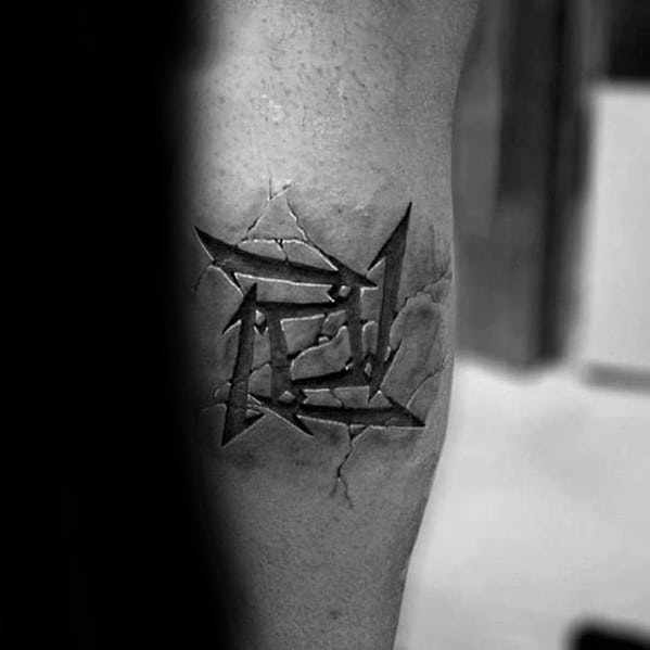 3D-style Metallica ninja star tattoo on the leg, designed to look cracked into the skin with realistic shadow and depth effects.