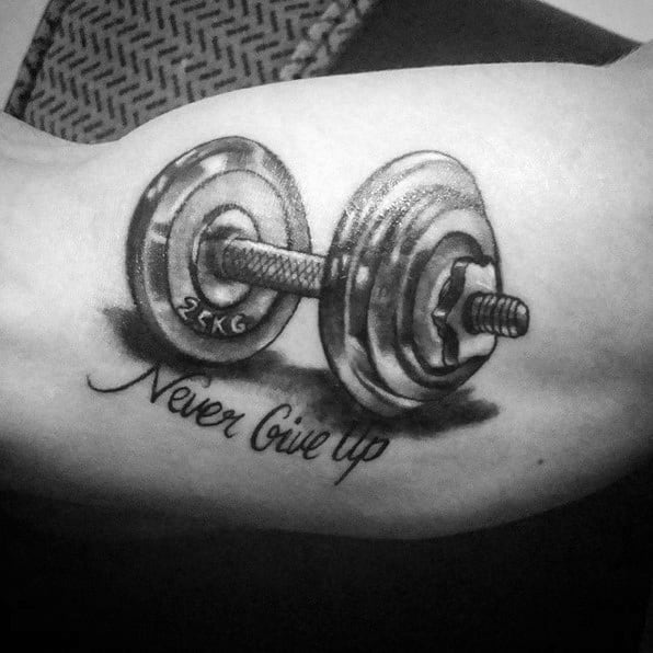 Realistic dumbbell tattoo with "Never Give Up" in script below, symbolizing perseverance, strength, and a no-quit mindset in training.