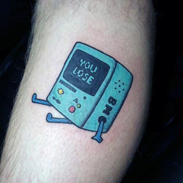 Adventure Time tattoo of a sad BMO with "YOU LOSE" on the screen, sitting with arms and legs out, inked on the lower leg.