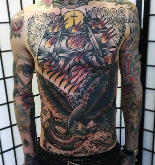 Full back tattoo of a burning church under a glowing sun with dramatic flames. A large black eagle with spread wings dominates the lower half.