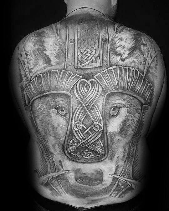 Full back Celtic wolf tattoo with realistic wolf face, armored design elements, and intricate knotwork at the center of the forehead.