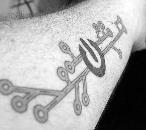 Power symbol tattoo merged with a circuit board design, inked on the arm to represent a fusion of tech and energy.