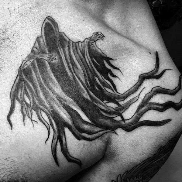 Black and grey chest tattoo of a Dementor with flowing, tentacle-like cloak strands reaching across the skin in eerie detail.