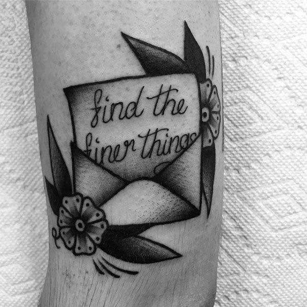 Tattoo of an envelope adorned with flowers and the phrase "find the finer things