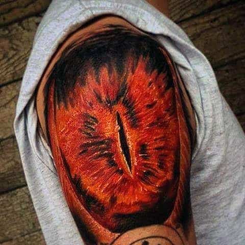 Tattoo of a fiery Eye of Sauron design on a person's upper arm