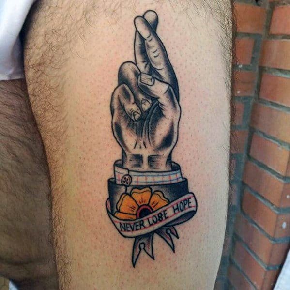 Male With Cool Fingers Crossed With Banner And Flower Tattoo Design Thigh