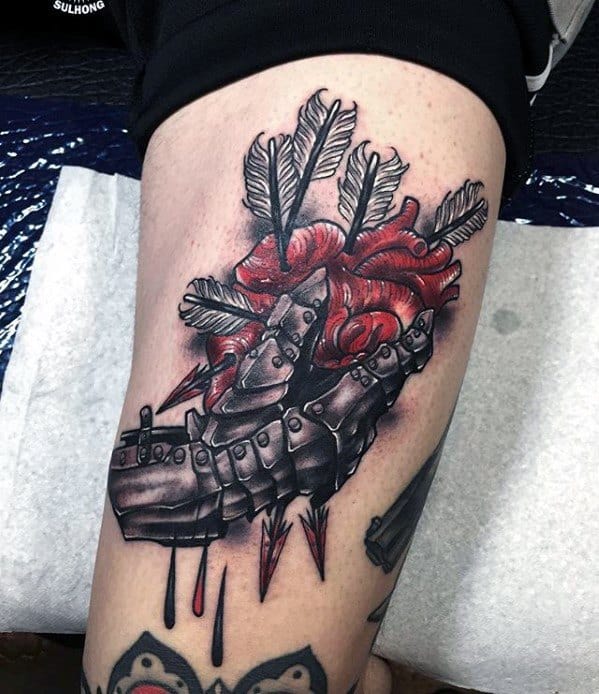 Realistic tattoo of a metallic gauntlet clutching a pierced red heart, with arrows and blood details emphasizing pain and emotion.
