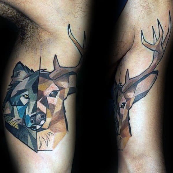 Colorful geometric tattoo of a half-wolf, half-deer design with antlers, featuring angular shapes and bold shading on the upper arm.