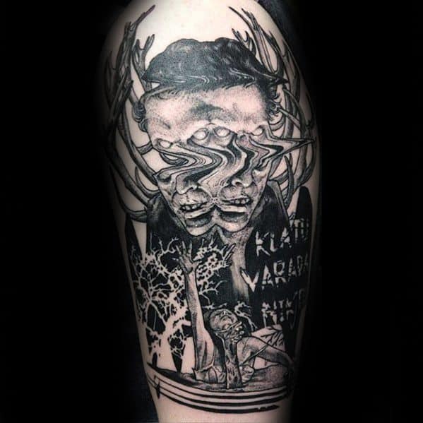 Glitch tattoo of a distorted face with antlers, overlapping eyes, and horror elements below, including trees and a figure raising a hand, with the phrase "Klaatu Barada Nikto" etched in eerie lettering