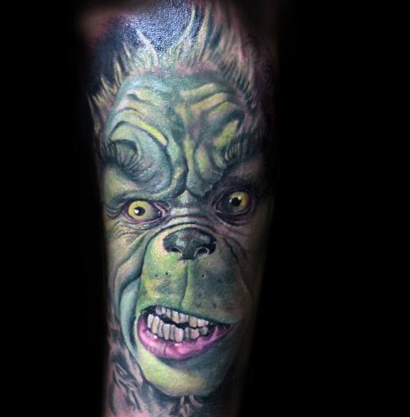 Highly detailed and vibrant Grinch face with a mischievous expression, capturing his green features and yellow eyes in a dynamic tattoo design.