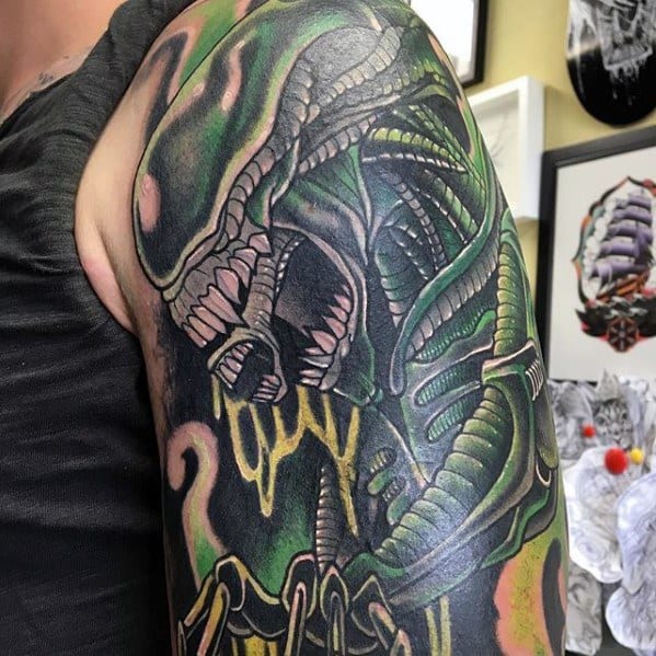 Colorful Xenomorph tattoo sleeve with vivid green and yellow tones, showcasing detailed claws, teeth, and biomechanical textures.