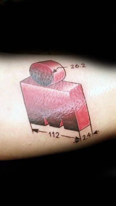Ironman logo tattoo featuring a 3D design with dimensions labeled for a marathon (26.2 miles) and a full triathlon (112 miles), symbolizing endurance.